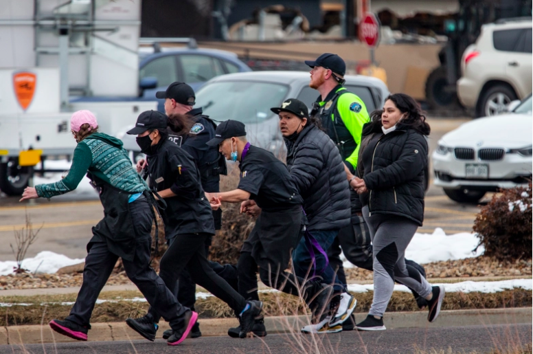 Los compradores son evacuados de una tienda de comestibles King Soopers después de que un hombre armado abrió fuego el 22 de marzo de 2021 en Boulder, Colorado.