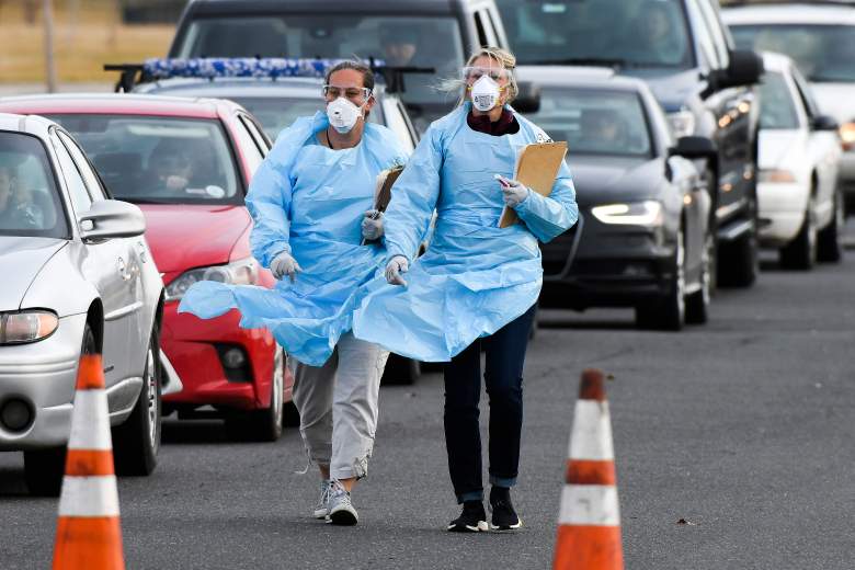 Los trabajadores de la salud del Departamento de Salud Pública y Medio Ambiente de Colorado se registran con las personas que esperan hacerse la prueba de COVID-19 en el primer centro de pruebas de conducción del estado el 12 de marzo de 2020 en Denver, Colorado.