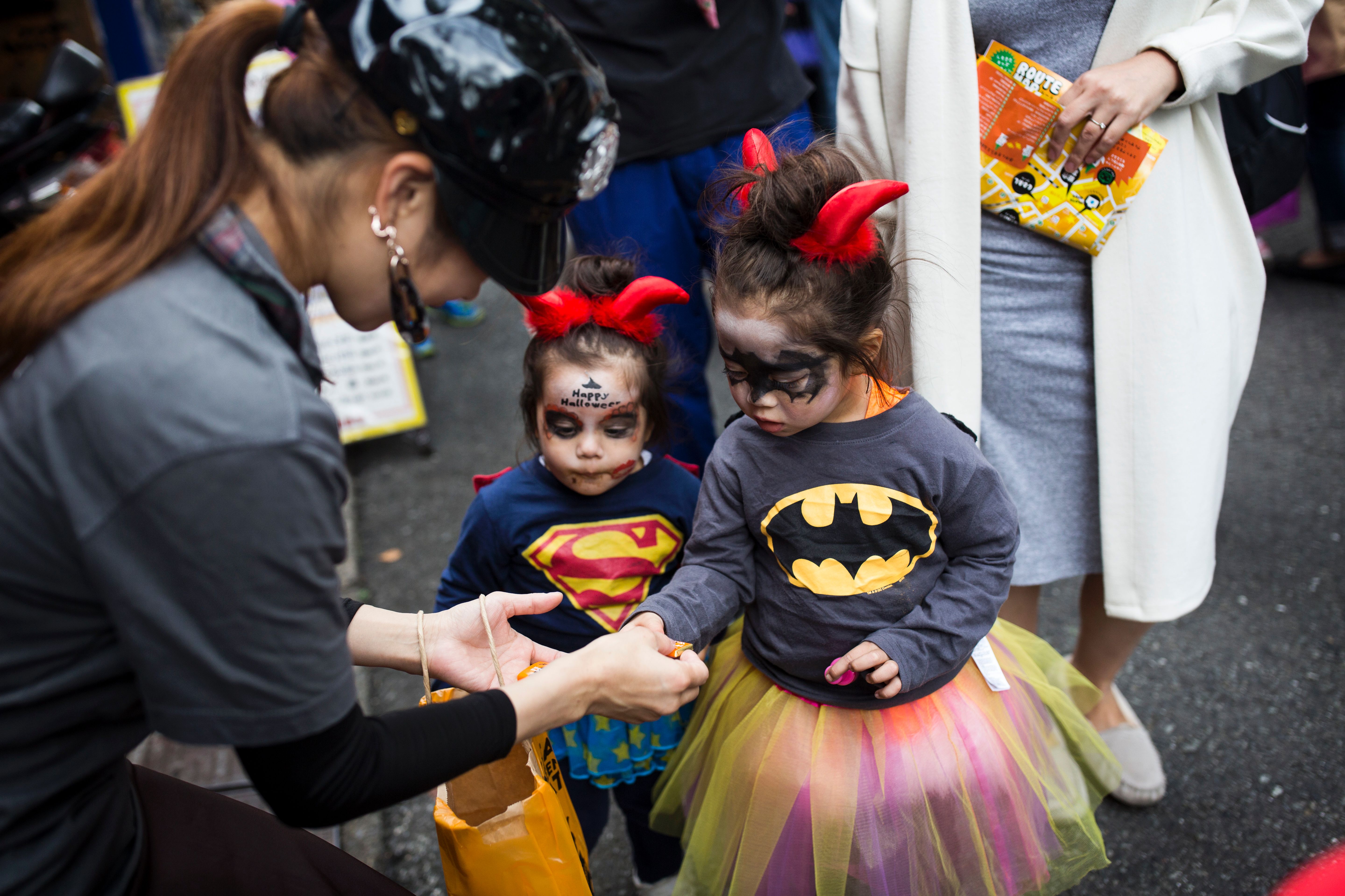 Esta foto tomada el 29 de octubre de 2016 muestra a niños japoneses disfrazados recibiendo dulces durante un desfile de Halloween en Tokio.