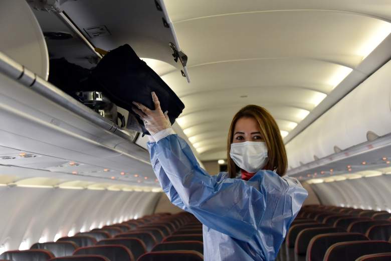 Una azafata con mascarilla y ropa de bioseguridad hace gestos en la cabina de pasajeros de un avión en el Aeropuerto Internacional El Dorado el 31 de agosto de 2020 en Bogotá, Colombia.